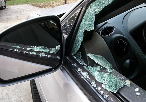 المتهم يقوم بكسر زجاج نوافذ السيارات للسرقة